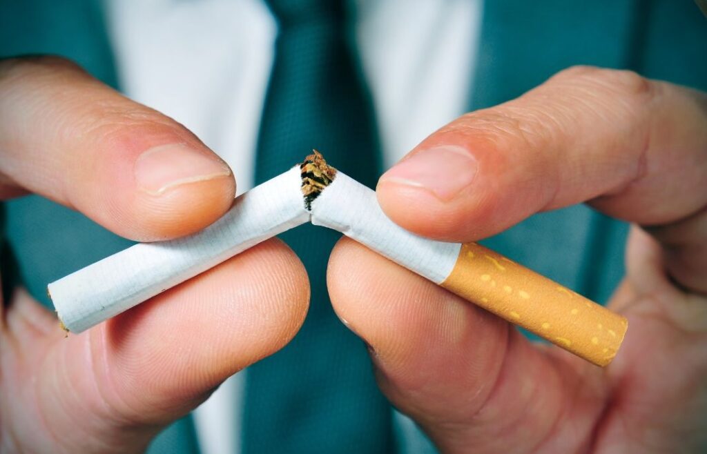 a man cutting a cigarette in half