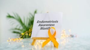 A sign with "Endometriosis Awareness Month" and a yellow ribbon.