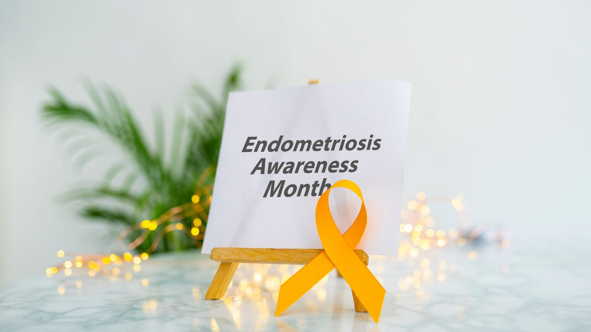 A sign with "Endometriosis Awareness Month" and a yellow ribbon.