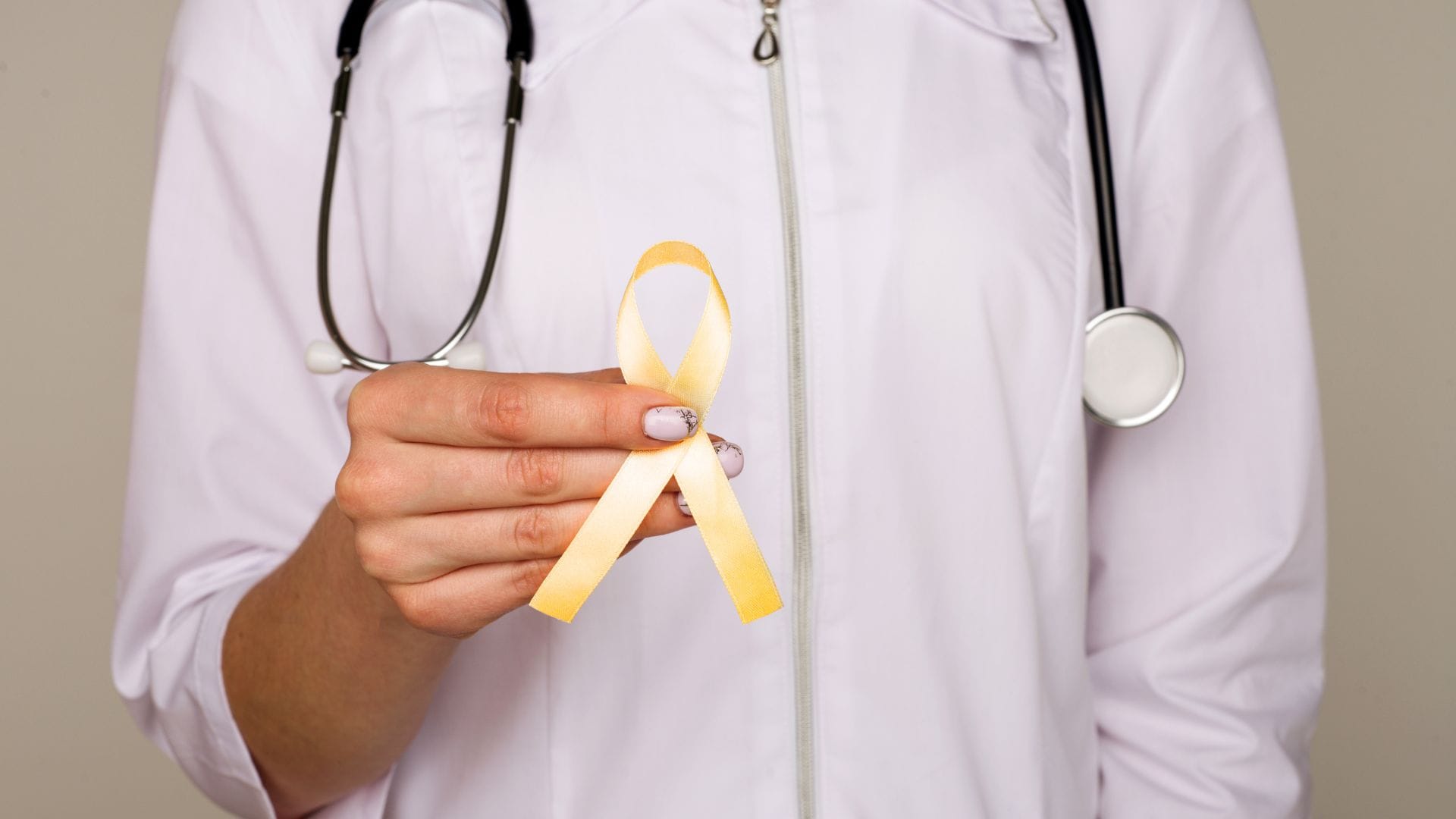 Doctor holding a yellow ribbon, symbolising endometriosis awareness.