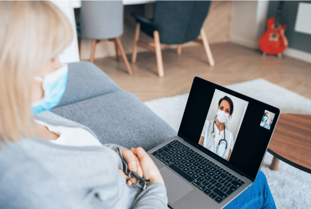 Person attending an online healthcare consultation with a doctor during a video call from home.