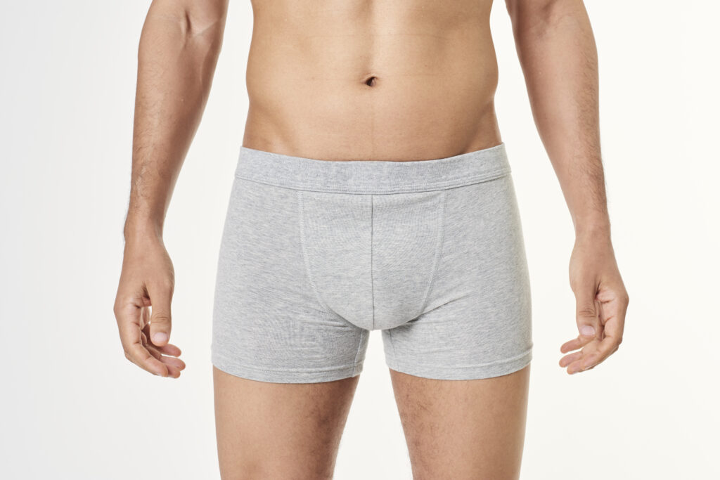 Man wearing grey boxer shorts, representing erectile dysfunction treatment and reviewing medication before travelling.