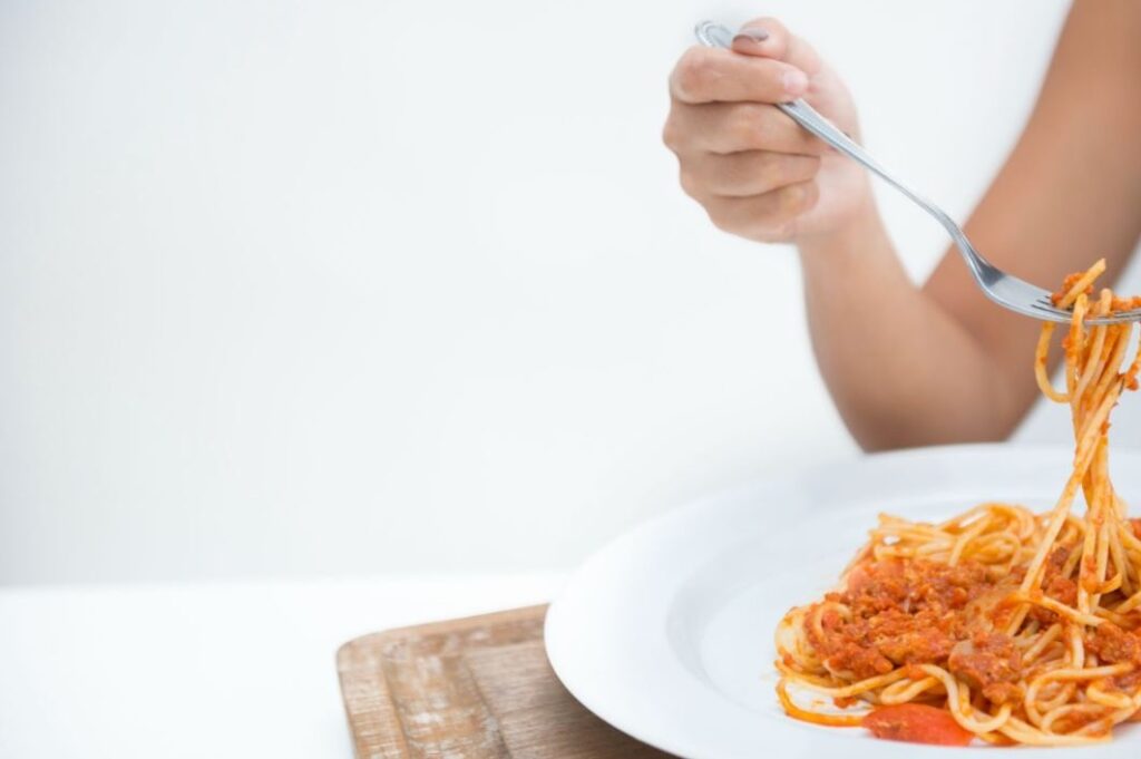 Person eating pasta during irregular working hours